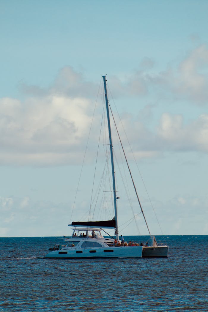 A peaceful sailboat glides over serene waters beneath a clear blue sky, evoking a sense of adventure and freedom.